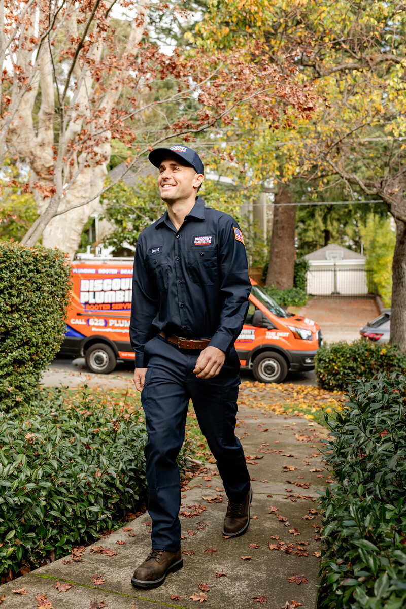 Discount Plumbing technician with van in the background walking up to a customers home
